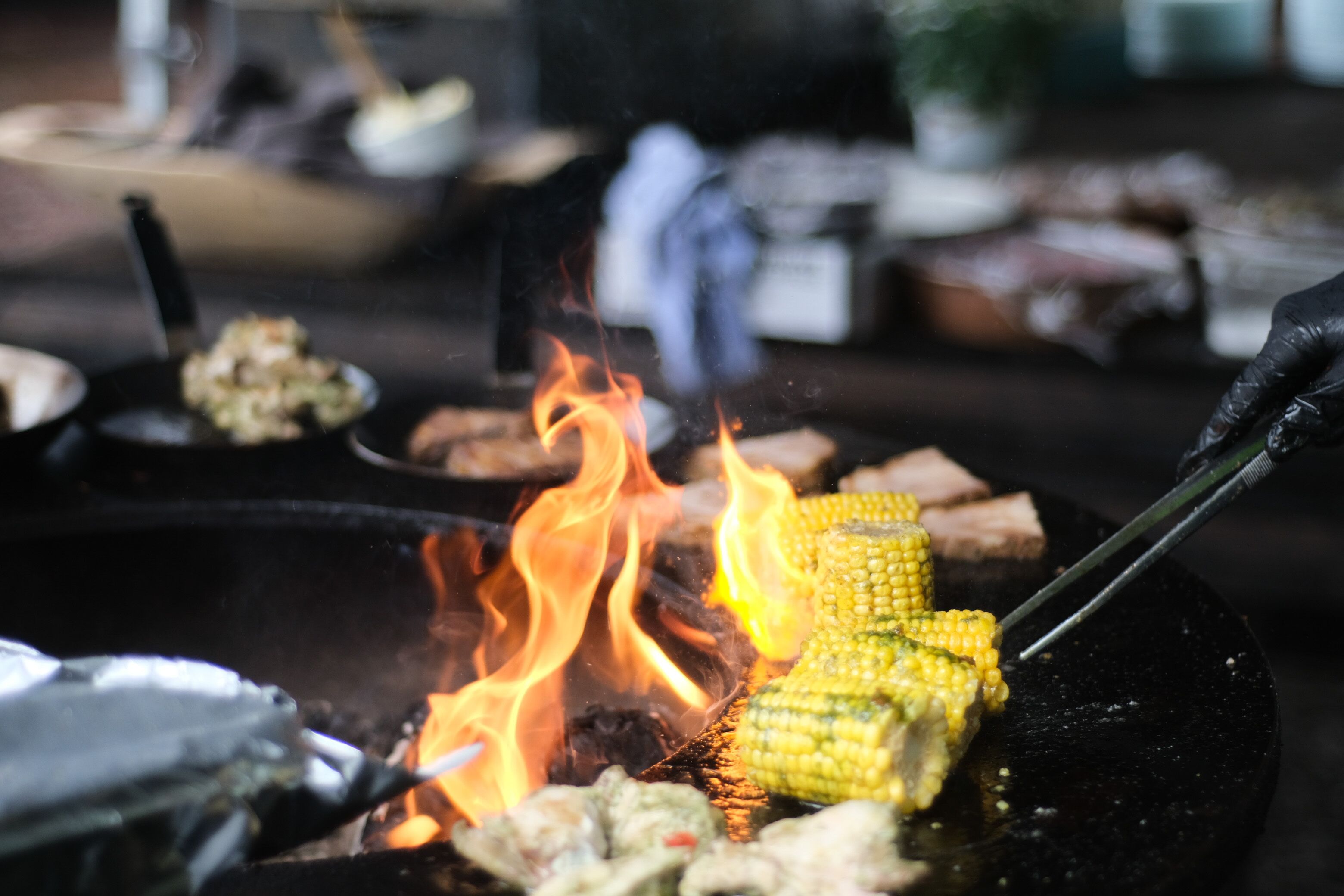 A grill with corn on fire.