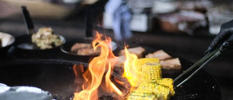 A grill with corn on fire.