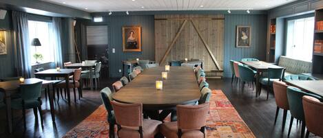 A conference room with a long table, multiple chairs, and a patterned carpet.