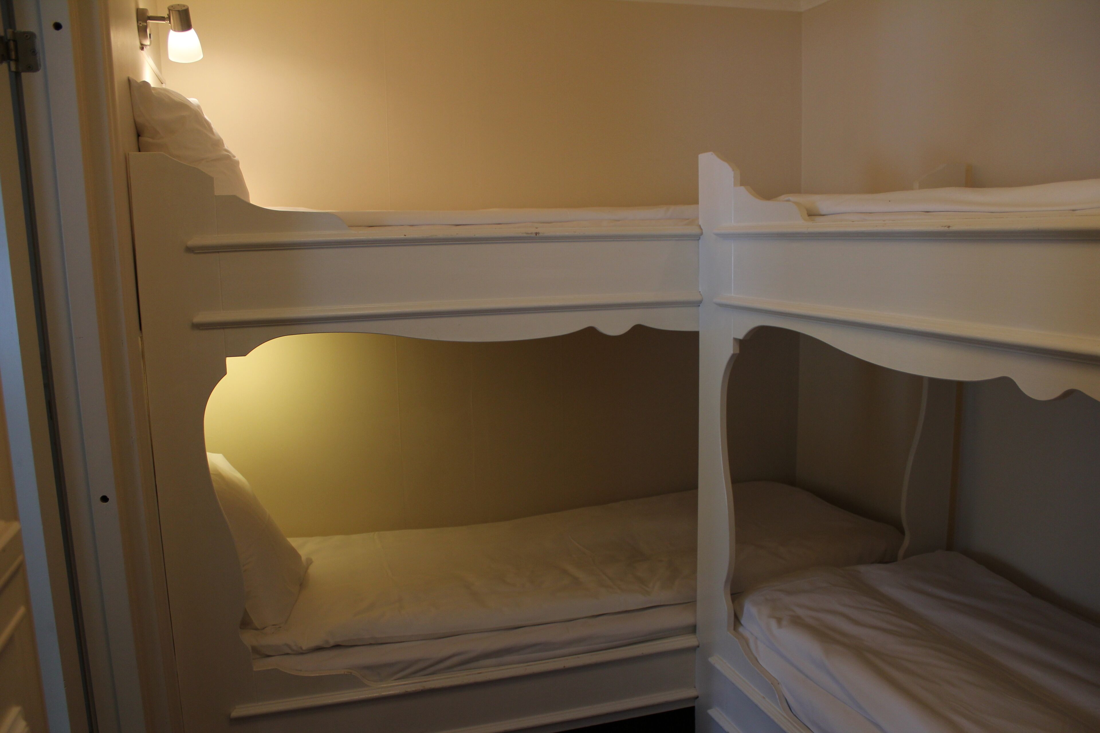 A bunk bed room with a single bed and a lower bunk.