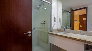 Une salle de bain moderne avec une douche à parois de verre, un meuble-lavabo à deux vasques et un grand miroir.