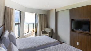 A hotel room with two beds, a TV, a chair, and a balcony with curtains. - Transamerica Prestige Recife - Boa Viagem (Recife)