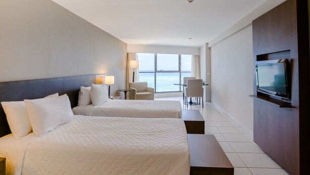 A hotel room with two beds, a TV, a desk, and a chair. - Transamerica Prestige Recife - Boa Viagem (Recife)