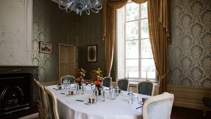 Un comedor formal con una mesa redonda dispuesta para seis comensales, rodeada por seis sillas.