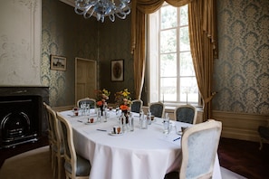 Un comedor formal con una mesa redonda dispuesta para seis comensales, rodeada por seis sillas.