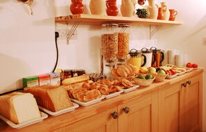 Ein Buffet mit Brot, Gebäck, Früchten und Beilagen.