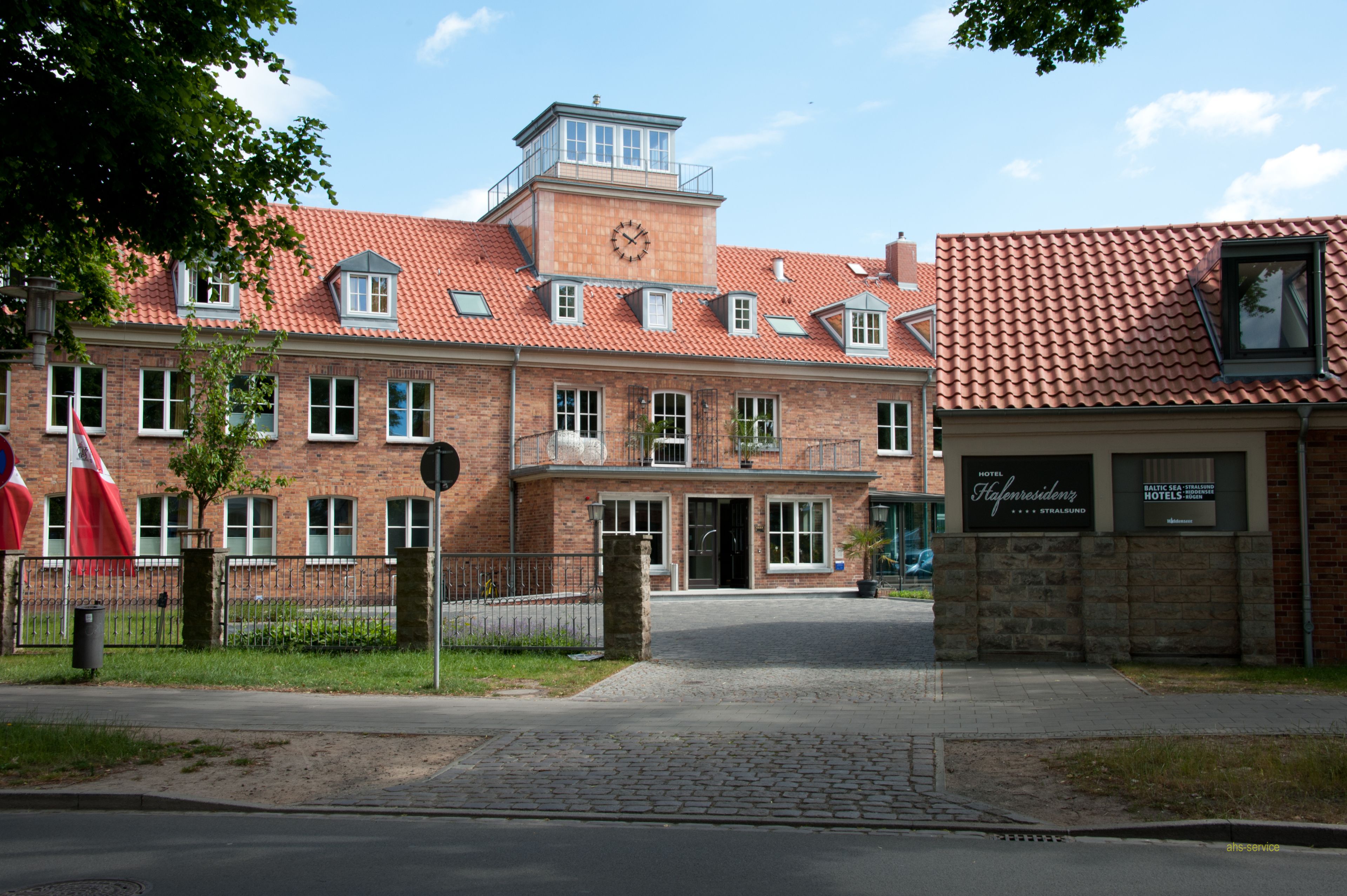 Ein Backsteinhaus mit rotem Ziegeldach, einem Glockenturm und einem Schild für Hotel Højresidenz.