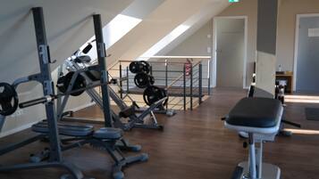 A gym with various exercise equipment, including weight machines and free weights.
