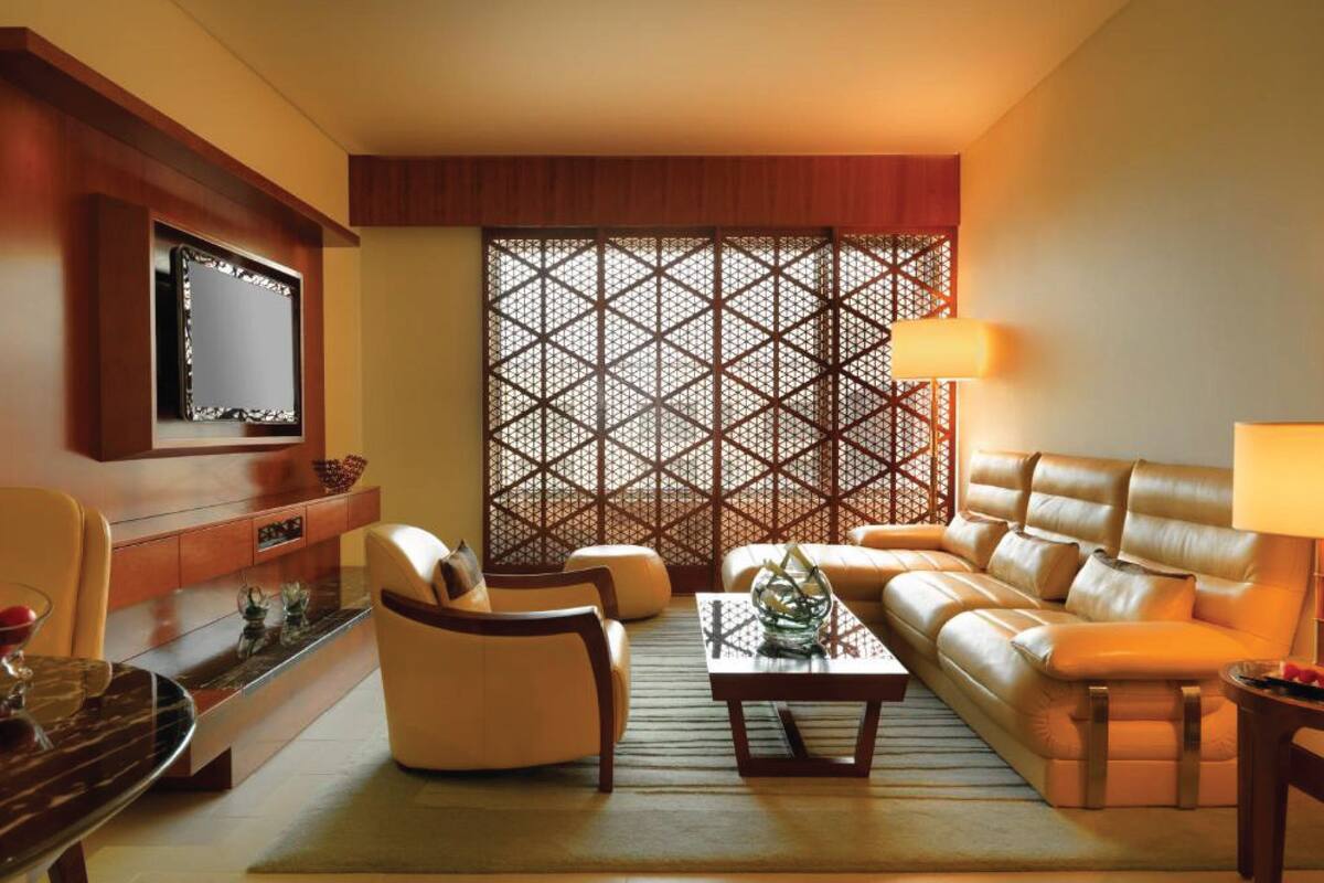 Una sala moderna con un sofá de cuero, una mesa de centro de madera y un televisor montado en la pared.