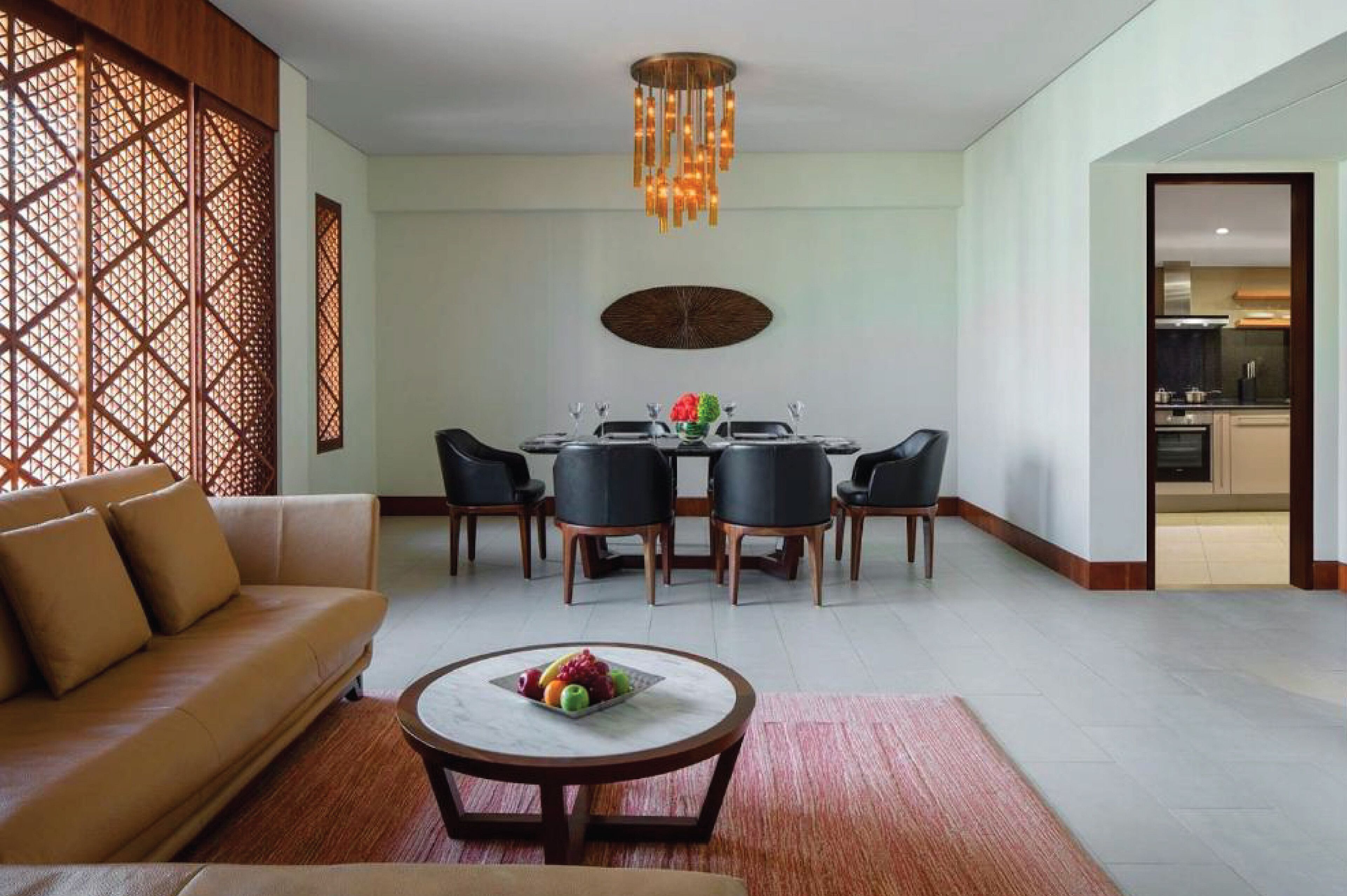 A modern living room with a sofa, dining table, chairs, and a coffee table.