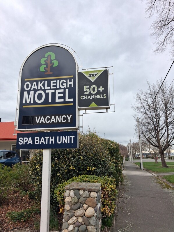 A motel sign with a vacancy notice and a spa bath unit. - Oakleigh Motel (Gore)