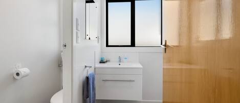 Un baño moderno con inodoro, lavabo y ventana.