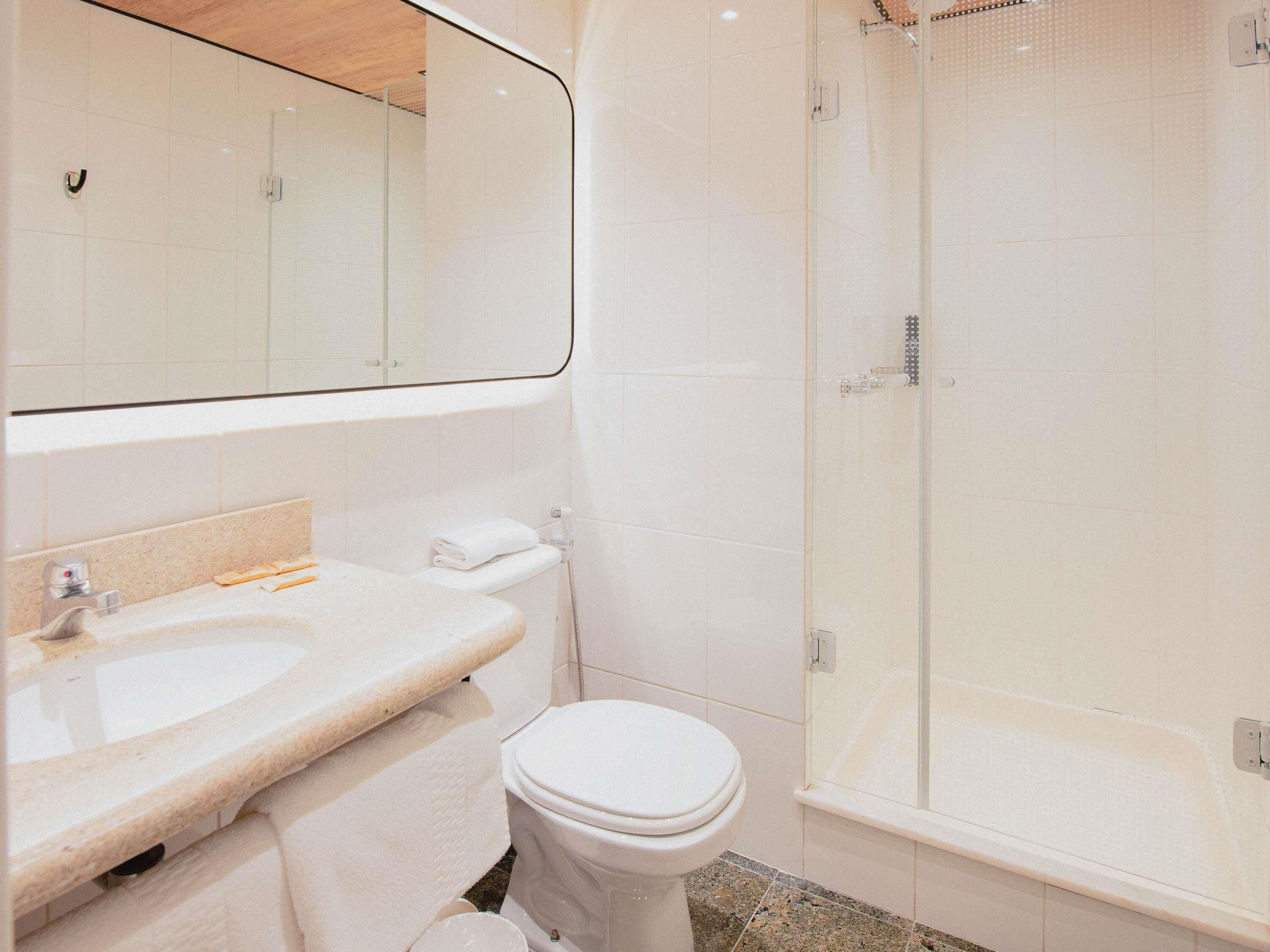 A modern bathroom with a sink, toilet, and glass-enclosed shower.