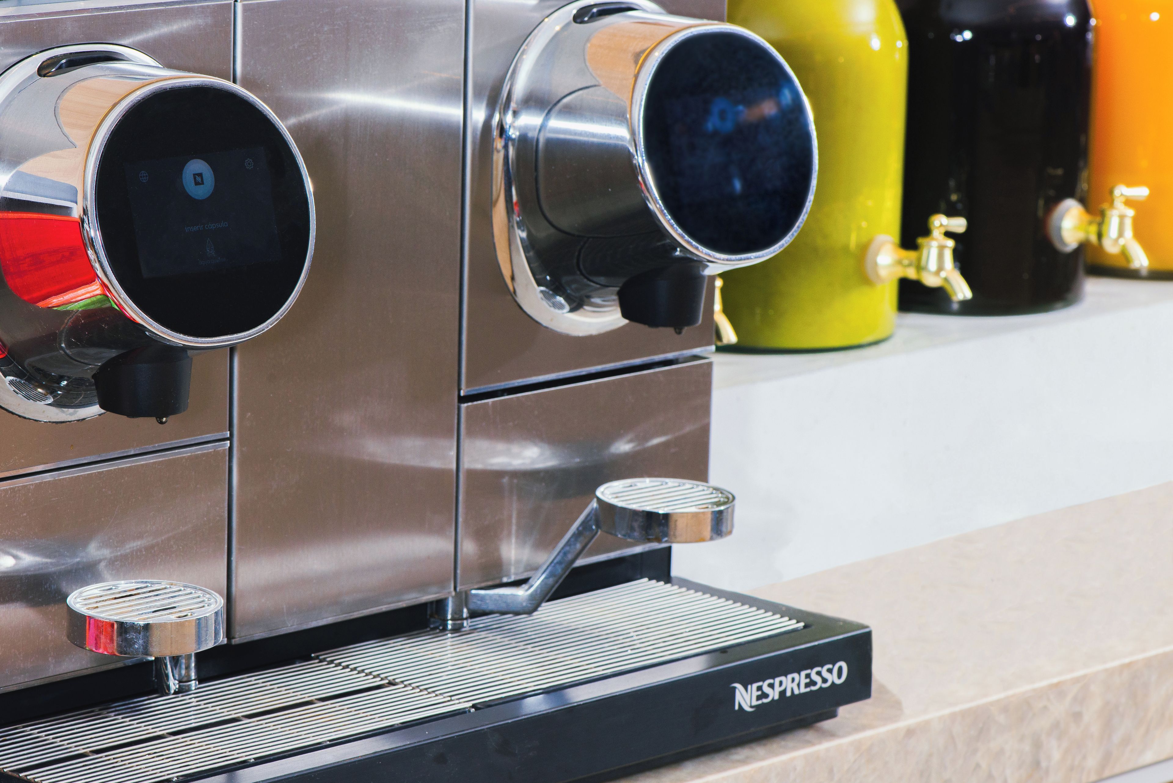 Una máquina de café espresso comercial con pantalla digital y múltiples boquillas de vapor.
