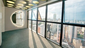 A modern interior with large windows, a curved wall feature, and a cityscape view. - Ibis Curitiba Shopping (Curitiba)