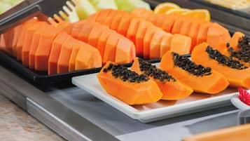 A tray of sliced papayas with black seeds on a white plate.