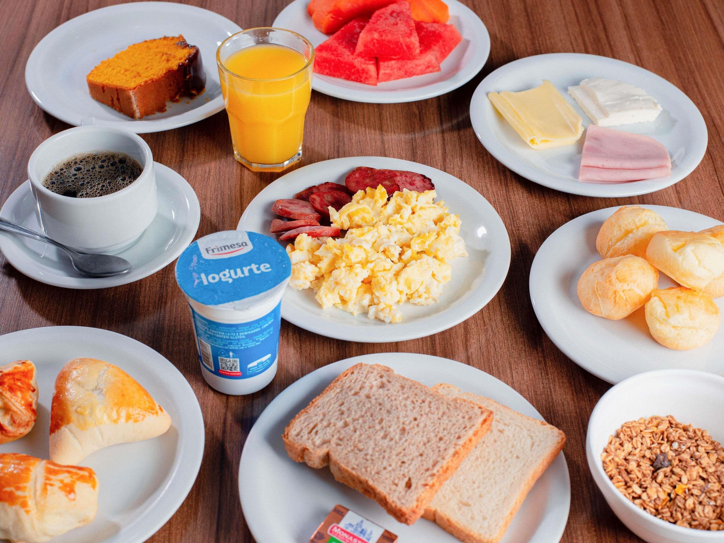 Una mesa con varios alimentos y una taza de yogur.