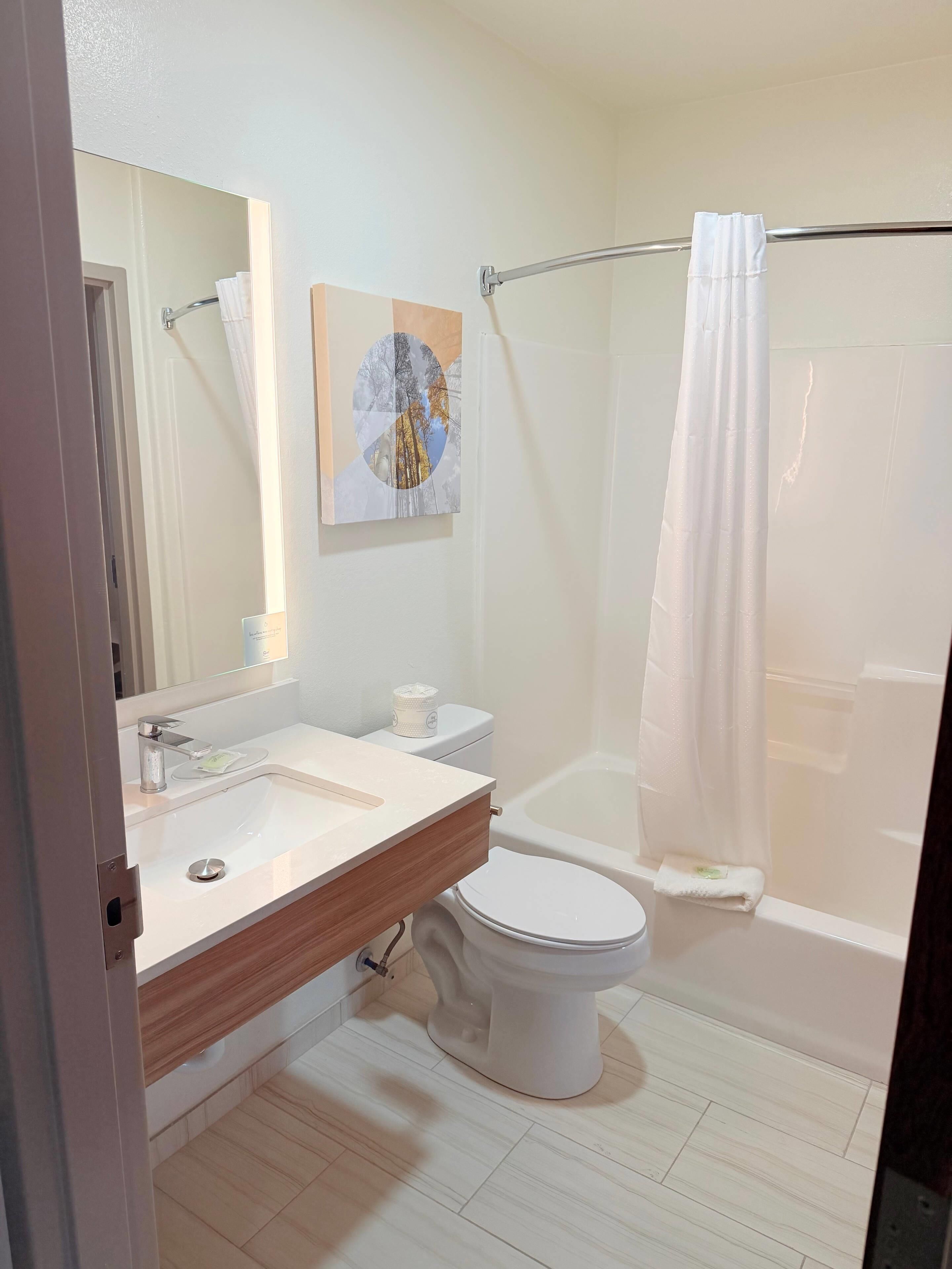 A bathroom with a sink, toilet, and shower.