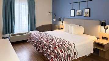 Escritorio, cortinas blackout y tabla de planchar con plancha