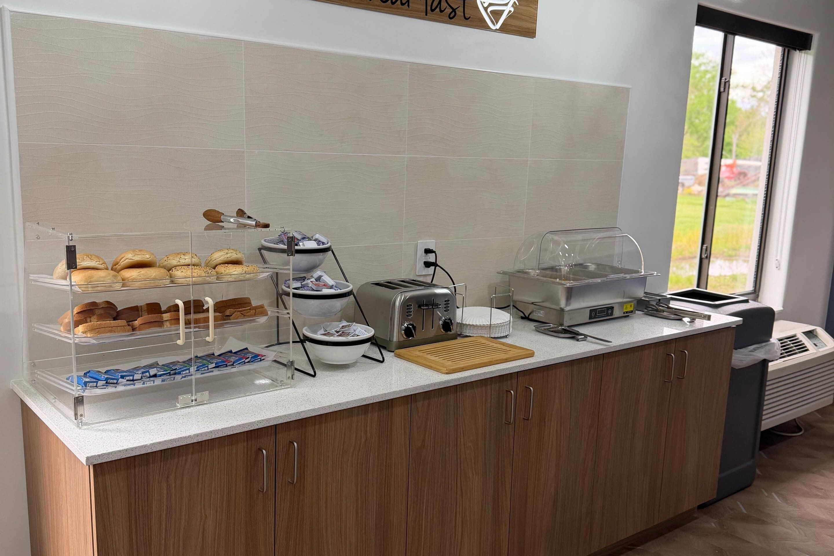 Una barra de desayuno con pan, bollería y una tostadora.