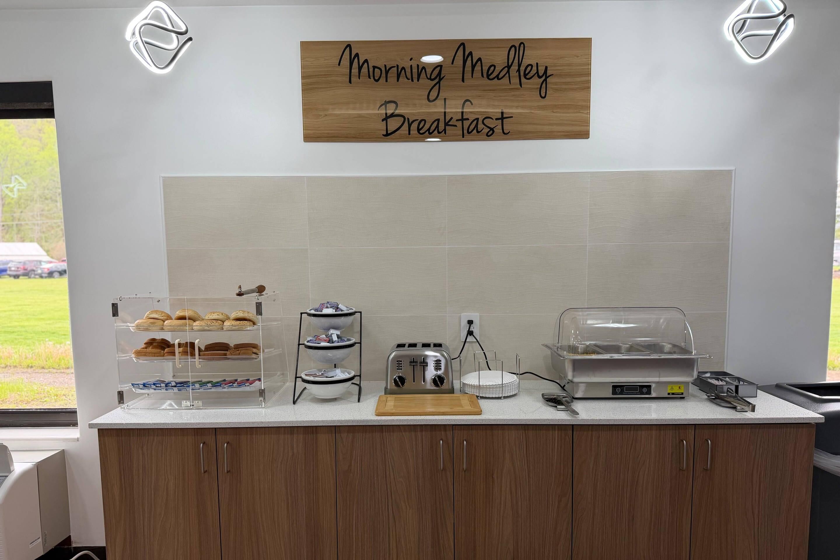 Un comptoir pour le petit-déjeuner avec une pancarte indiquant « Petit-déjeuner du matin », un grille-pain, une machine à café et un présentoir à pain.
