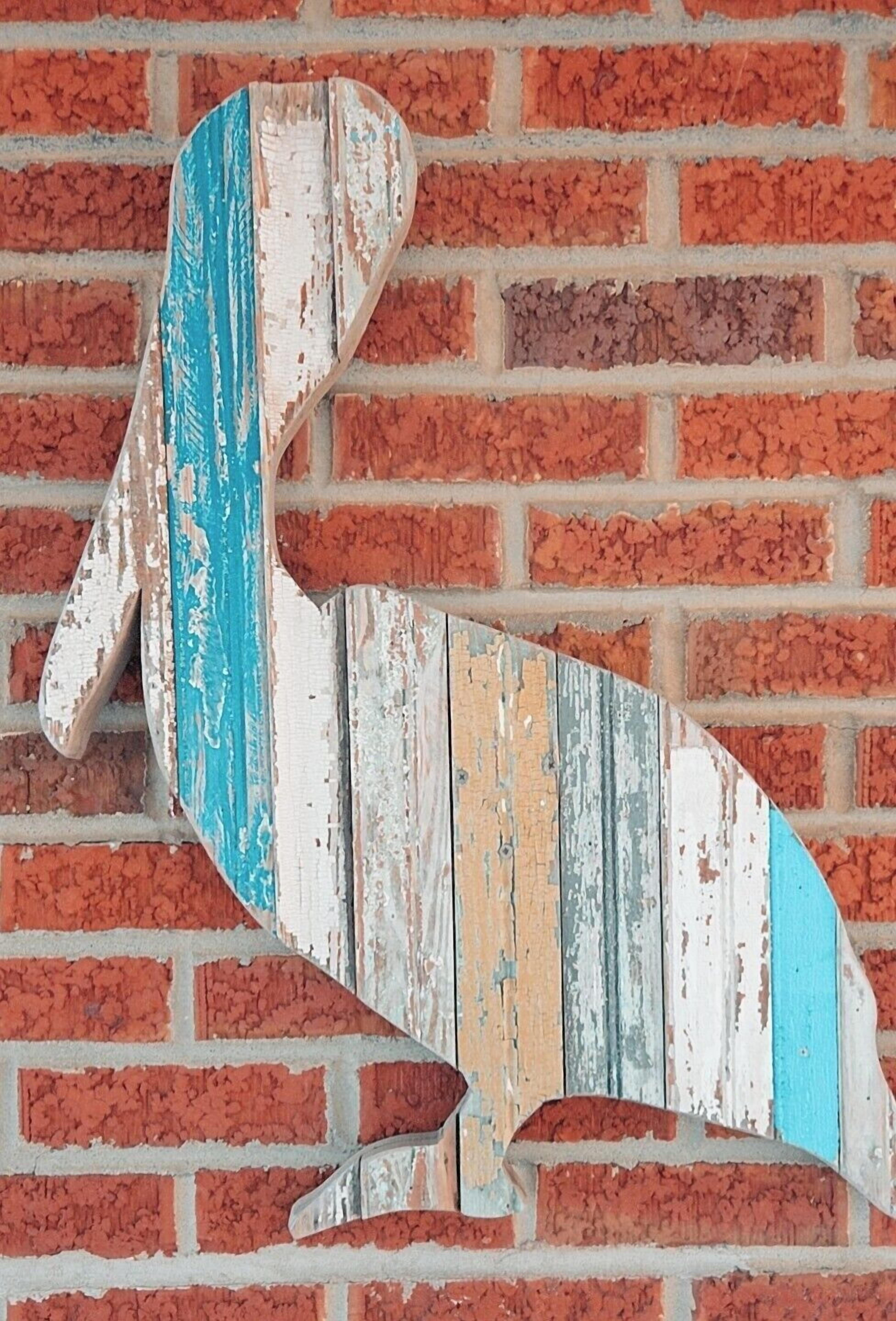 A rustic wooden sign with a distressed finish against a brick wall.