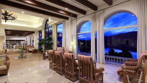 A spacious lobby with high ceilings, large arched windows, and a seating area with wicker chairs. - Miyako Resort Shima Bayside Terrace (Shima)