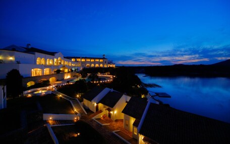 A large resort with multiple buildings, a swimming pool, and a waterfront view.