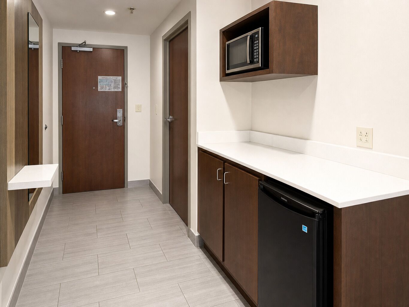 A kitchen with a microwave, cabinets, and a dishwasher.