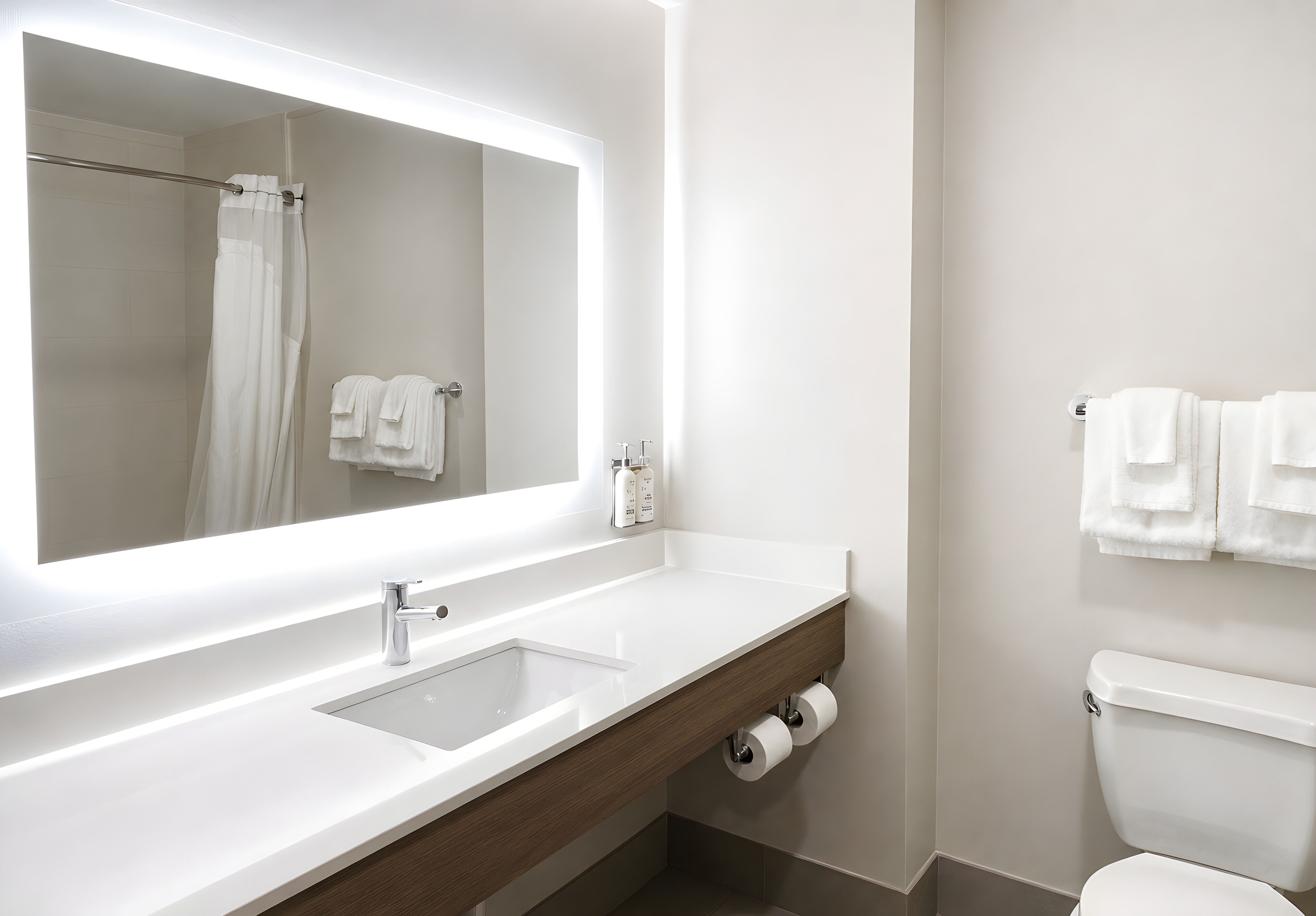 A modern bathroom with a large mirror, a sink, a toilet, and a shower curtain.