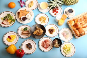 A breakfast spread with various dishes and fruits on a blue table. - Castle Plaza Hotel (Nagoya)