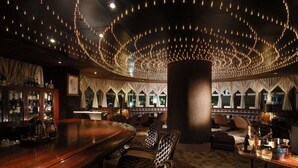 A bar area with a wooden counter, upholstered chairs, and a large central column. - Castle Plaza Hotel (Nagoya)