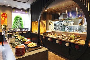 A buffet setup with various food items and a kitchen area in the background. - The Royal Park Hotel Fukuoka (Fukuoka)