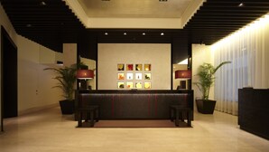 A reception area with a reception desk, potted plants, and framed artwork on the wall. - The Royal Park Hotel Fukuoka (Fukuoka)