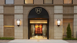 A hotel entrance with a prominent archway, a logo above the entrance, and two wall-mounted lights on either side. - The Royal Park Hotel Fukuoka (Fukuoka)