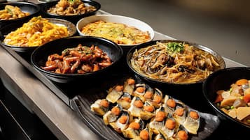 A buffet with various dishes including seafood, pasta, and vegetables.