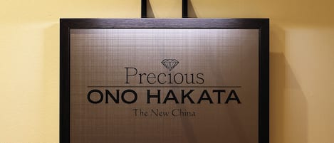 A framed sign with the text "Precious ONO HAKATA The New China".