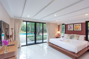 Un dormitorio moderno con una cama grande, un escritorio y vistas a una piscina.