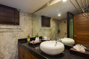 Un baño con un espejo grande, dos lavamanos y una puerta de madera.