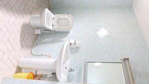 A bathroom with a toilet, bidet, and a shower area. - Prestige Hotel (Yaoundé)