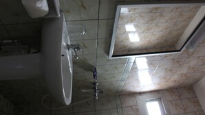 A bathroom with a toilet, sink, and shower. - Prestige Hotel (Yaoundé)