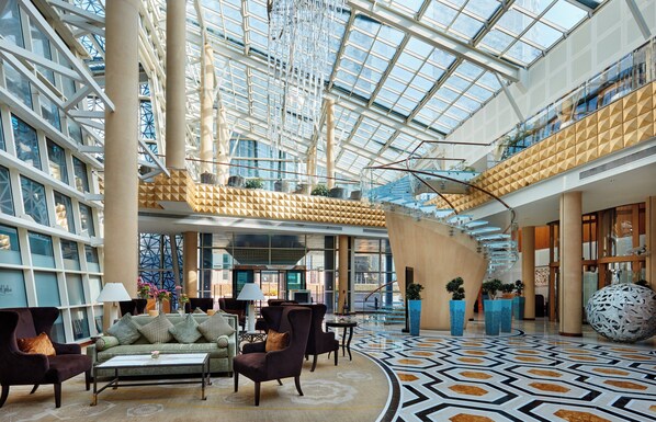 Un hall d’entrée spacieux, doté d’un haut plafond, de grandes fenêtres et d’un design moderne.