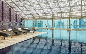 Una piscina al aire libre, sillones reclinables de piscina