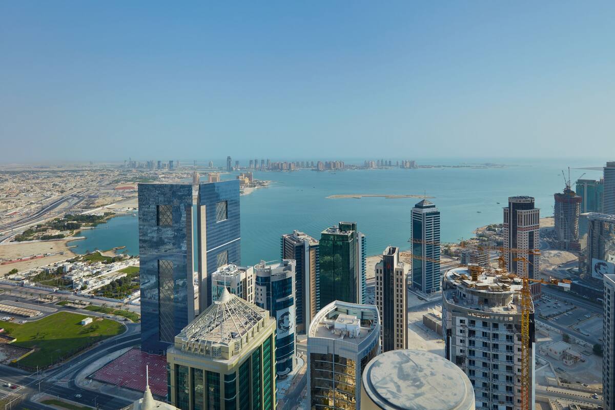 A high-rise building with a modern architectural design, featuring a prominent glass facade and a rooftop terrace.