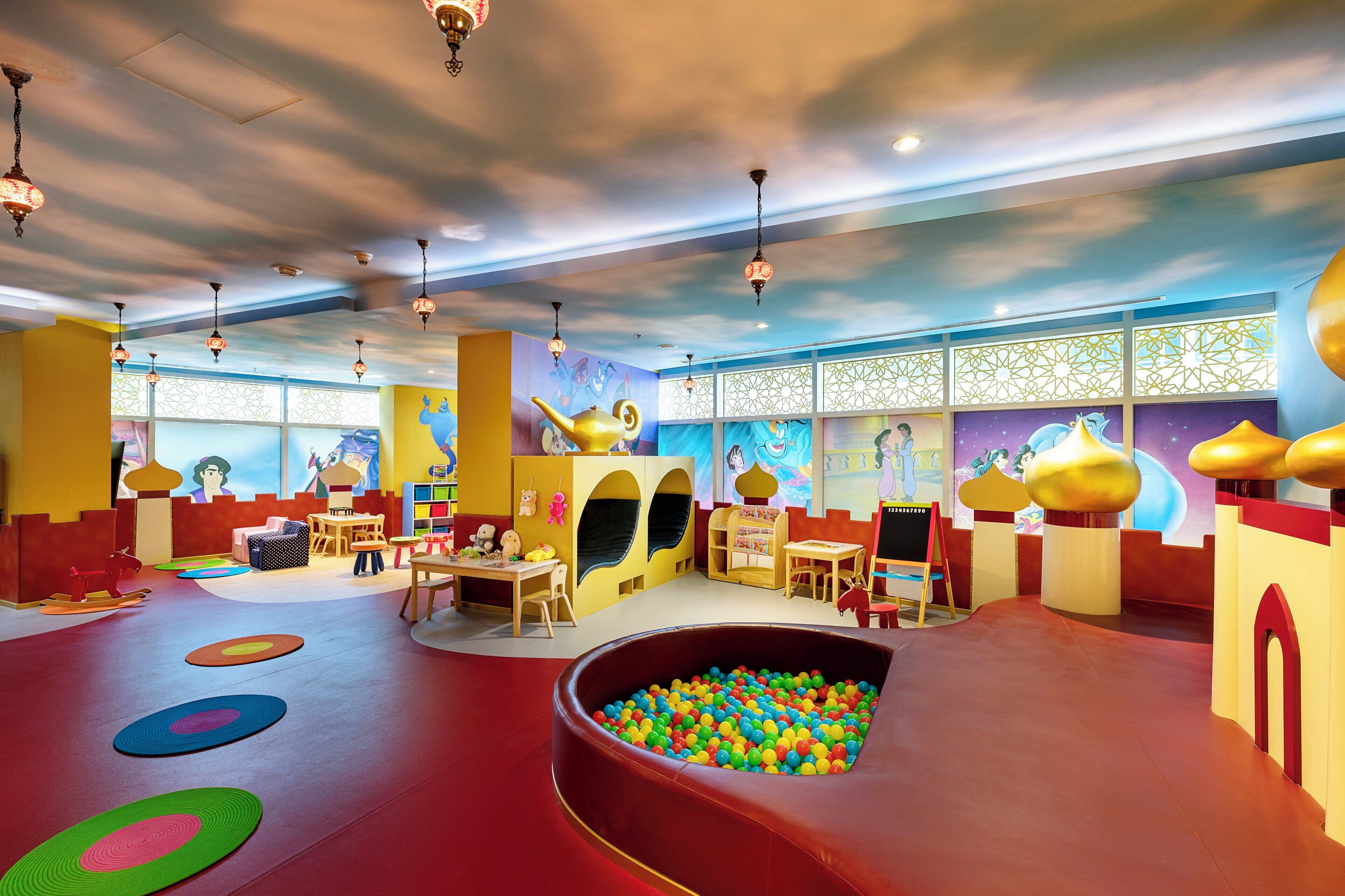 Spielbereich für Kinder mit Bällebad, Sitzgelegenheiten und lehrreichen Wandbildern.