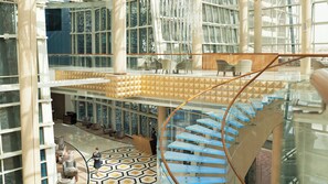 A multi-level atrium with a glass staircase and seating areas. - InterContinental Doha The City by IHG (Doha)