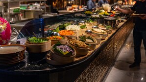 A buffet with various food items and a person serving. - InterContinental Doha The City by IHG (Doha)