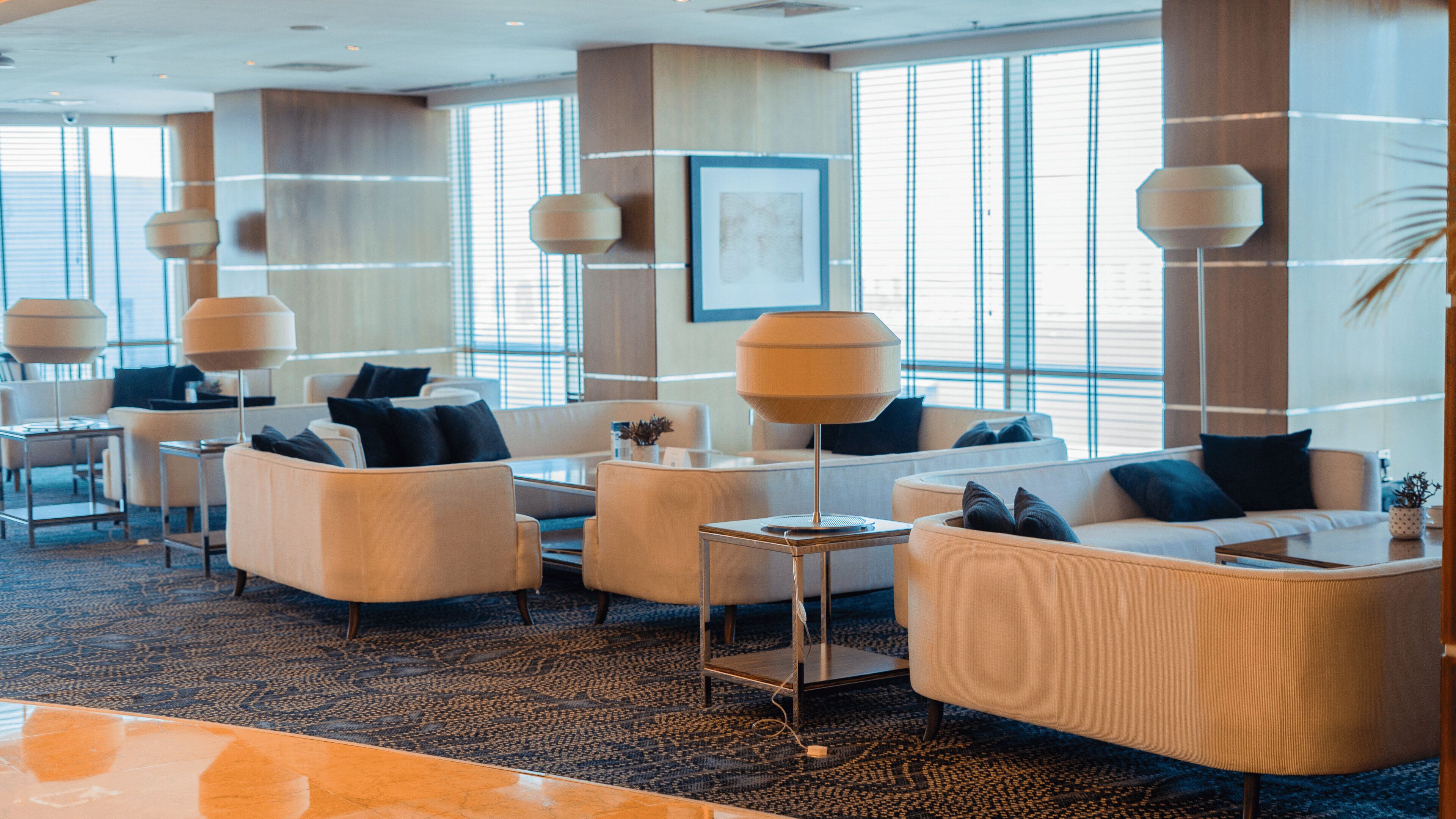 En moderne hotellobby med sofaer, borde og store vinduer.