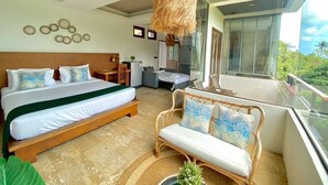 Een moderne hotelkamer met een groot bed, een bank, een zithoek en een balkon met uitzicht.