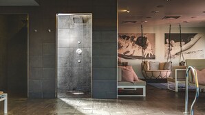 A modern spa area with a large shower, a seating area with a swing chair, and a pool. - Harbour Hotel Guildford (Guildford)